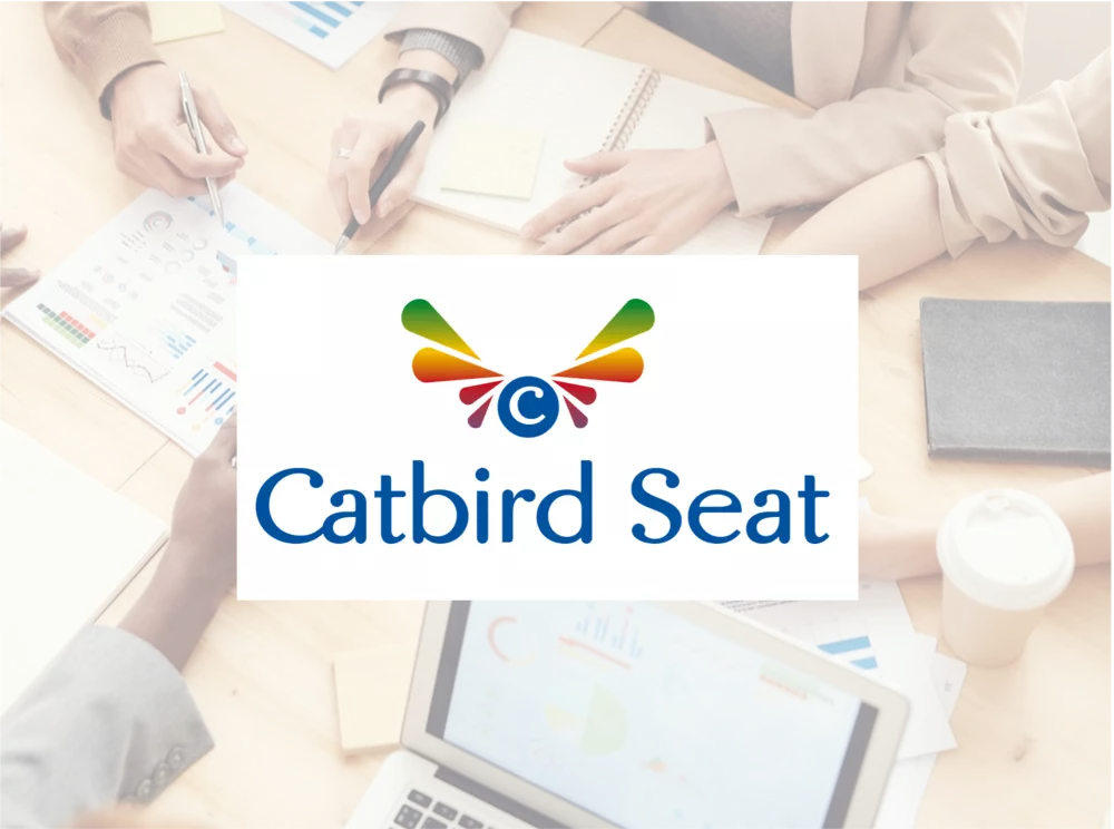 The Catbird Seat logo on a ground picture, which shows an office workplace. 