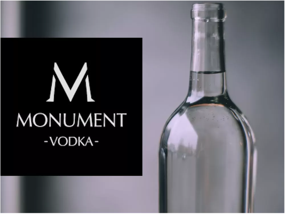 The picture shows the MONUMENT VODKA logo on the left and a photo of such a vodka bottle on the right. 